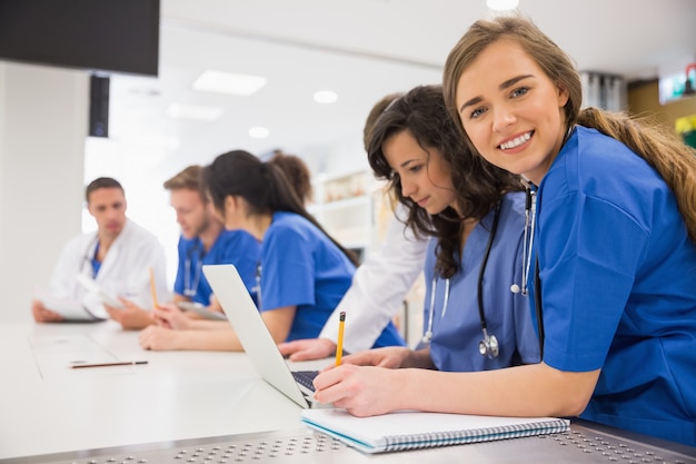 Foto estudante de medicina sorrindo para a câmera durante a aula