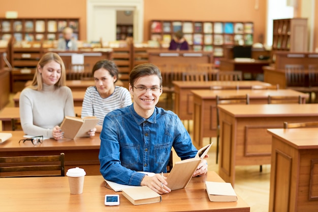 Estudante diligente animado na biblioteca