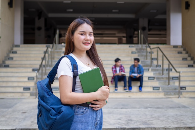 Estudante do ensino médio segurando livros no campus