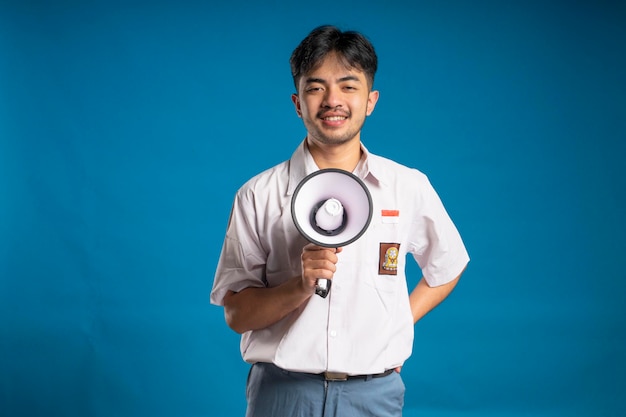 Foto estudante do ensino médio segurando megafone sorrindo olhando para a câmera