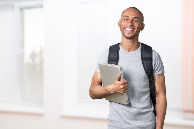 Estudante do sexo masculino com mochila no fundo