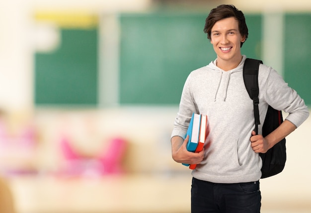 Estudante do sexo masculino com mochila no fundo