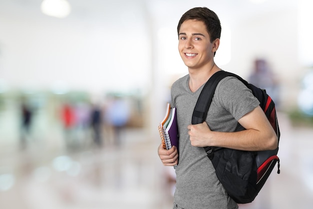 Estudante do sexo masculino com mochila no fundo