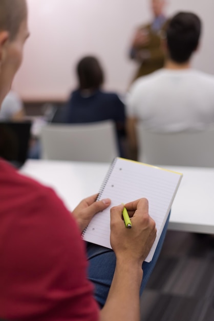 estudante do sexo masculino tomando notas em sala de aula. conceito de educação empresarial, jovem empresário casual em treinamento de seminário