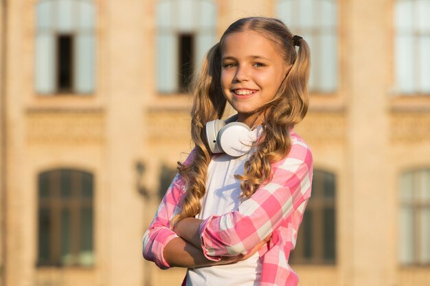 Estudante. Educação moderna. Música de escuta adolescente alegre. Estudante elegante indo para a escola. Menina com mochila. Vida escolar. Tendo um bom dia na escola. Criança feliz e despreocupada. Aulas escolares.