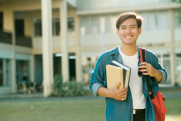 Estudante em pé ao ar livre e segurando livros