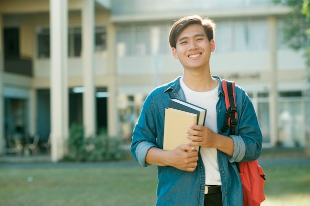 Estudante em pé ao ar livre e segurando livros