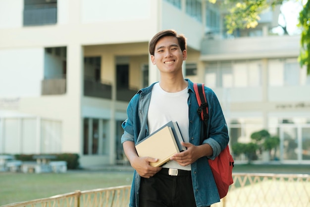 Estudante em pé ao ar livre e segurando livros