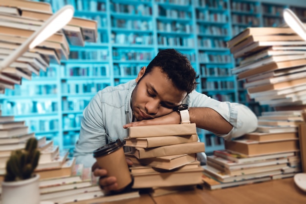 Estudante está dormindo na biblioteca à noite