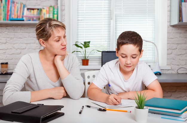 estudante estuda em casa e faz os deveres de casa. ensino à distância em casa, educação infantil online, ensino doméstico. Quarentena e conceito de distanciamento social.