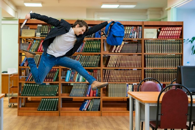 Foto estudante feliz pulando com livros e mochila b