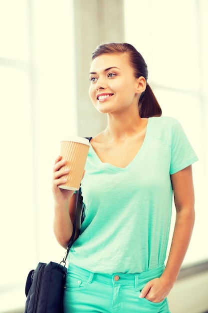 Foto estudante feliz segurando a xícara de café