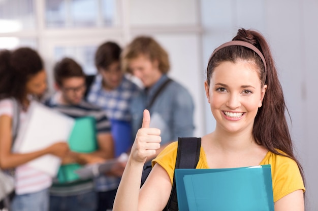 Estudante feminina gesticulando polegares na faculdade