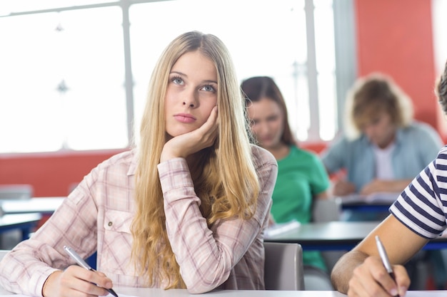 Estudante feminina pensativa na sala de aula