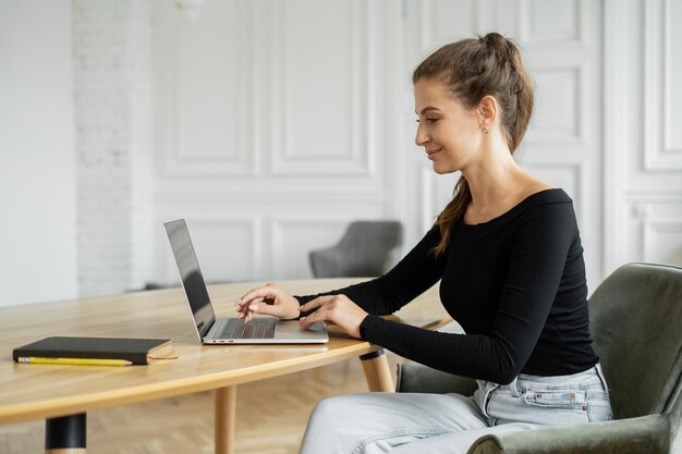 Estudante freelancer feminina trabalhando no escritório usando espaço de coworking para laptop para alugar