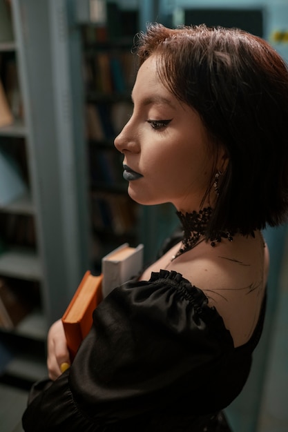 Foto estudante gótico na biblioteca da escola