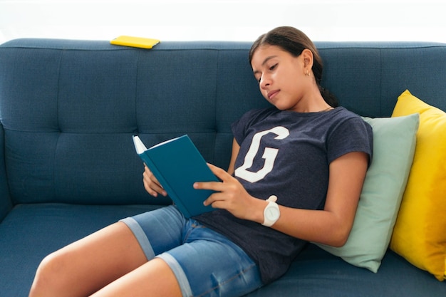 Estudante hispânico lendo um livro. O conceito voltou para a escola