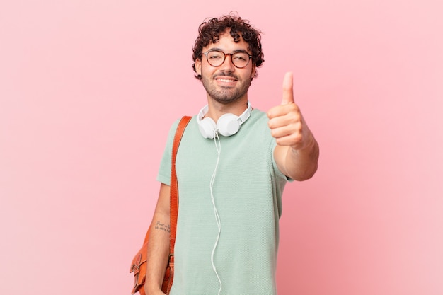 Estudante hispânico sentindo-se orgulhoso, despreocupado, confiante e feliz, sorrindo positivamente com o polegar para cima