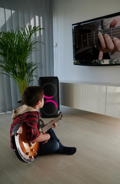 Foto estudante independente conectado para aprender a tocar guitarra elétrica