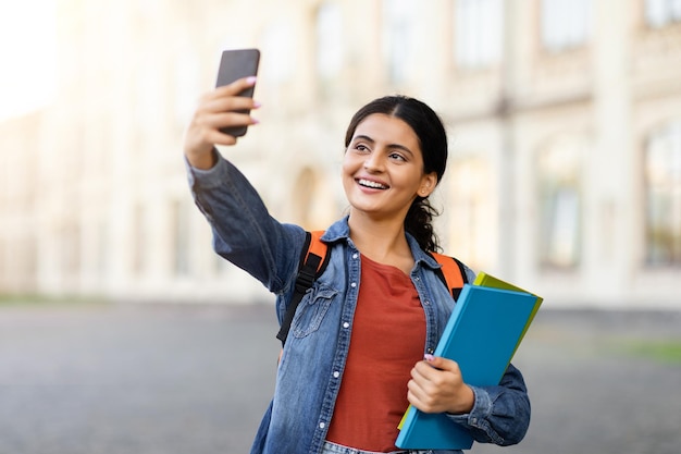 Foto estudante indiano a tirar uma selfie com o telemóvel