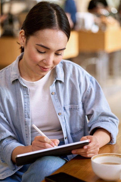 Estudante jovem asiática usando tablet digital para e-learning