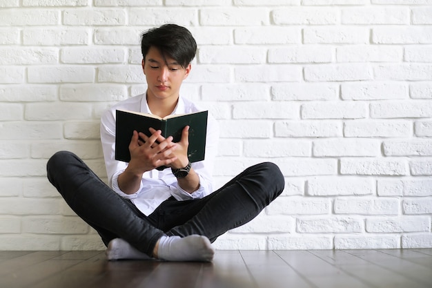 Estudante jovem asiático com livros nas mãos