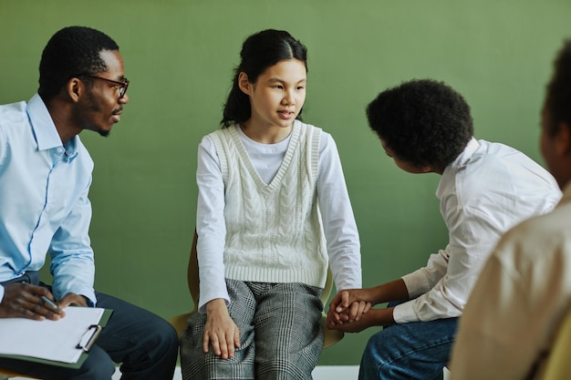 Estudante jovem falando com estudante segurando suas mãos durante a discussão de seus problemas no psyc