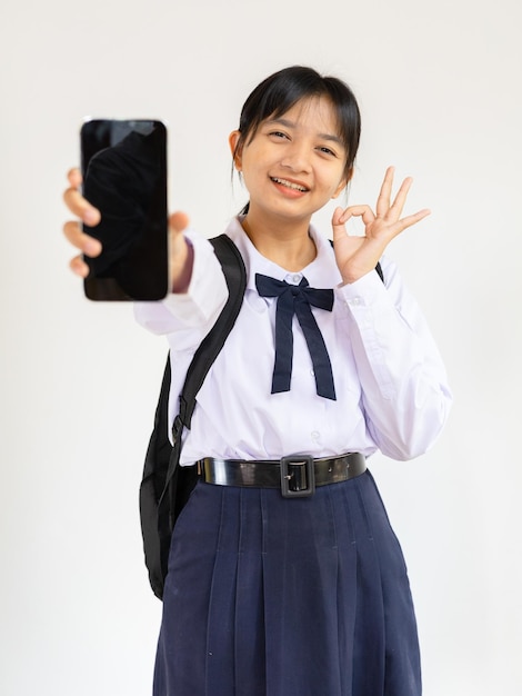 Estudante jovem usando telefone móvel com mochila em fundo branco