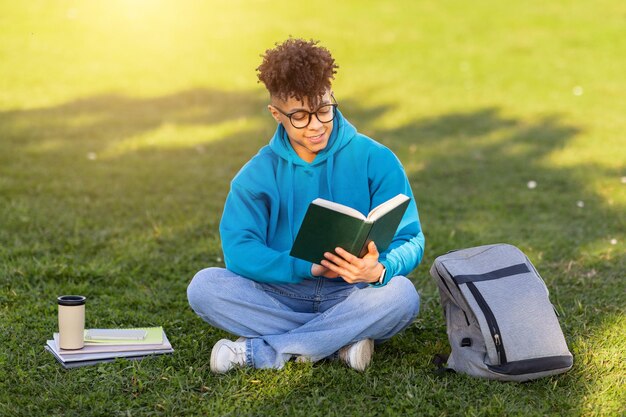 Estudante lendo um livro na grama