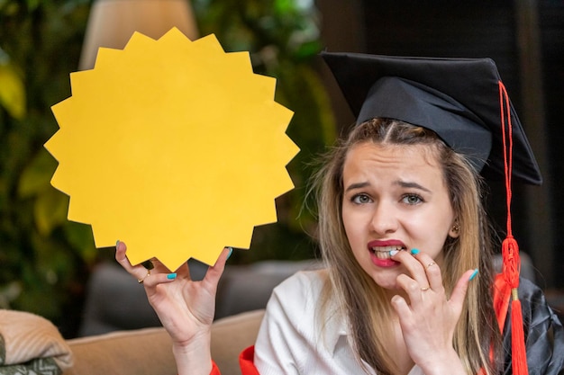 Foto estudante loira bonita segurando o quadro de ideias e olhando para a câmera