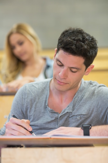 Estudante masculino sério durante a aula na sala de aula