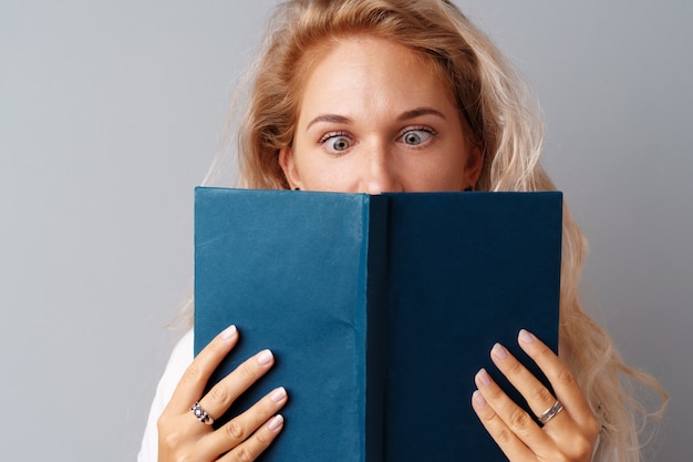 Estudante menina adolescente segurando um livro nas mãos dela