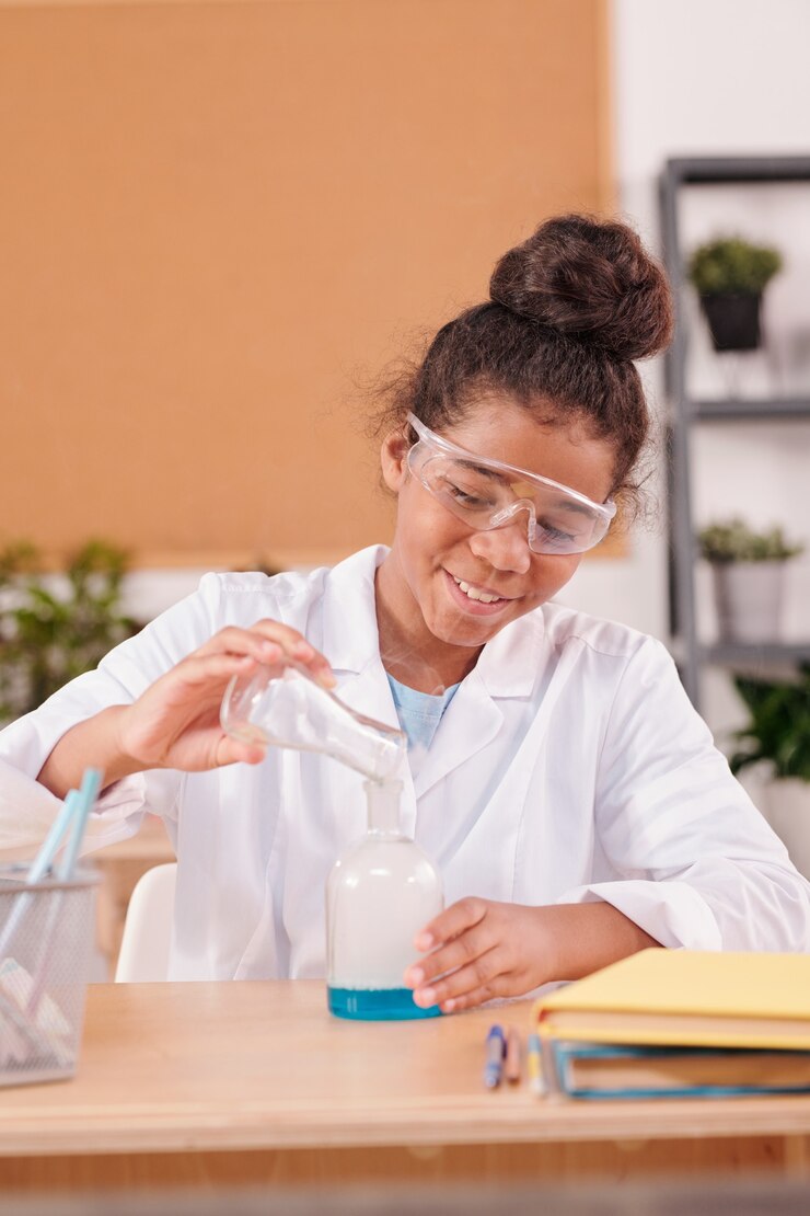Foto estudante mestiça sorridente despejando substância líquida do tubo em um bico grande durante experimento químico na aula de química