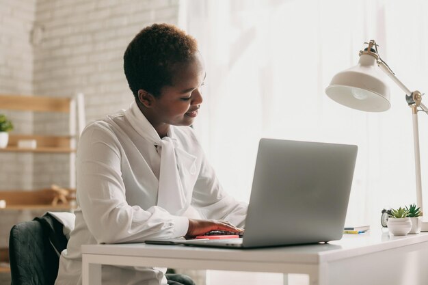 Foto estudante negro escrevendo notas assistindo webinar no laptop estudando on-line participando do seminário de reunião de negócios virtual