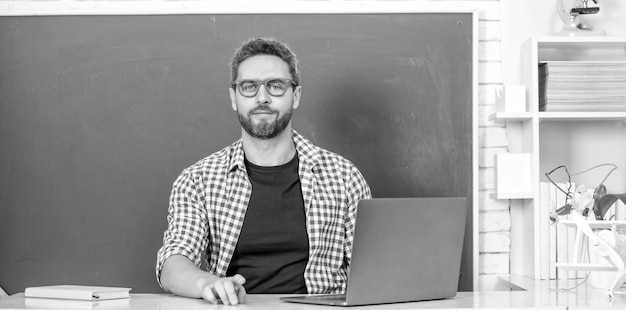 Estudante nerd estuda professor particular online em sala de aula com quadro-negro no pc