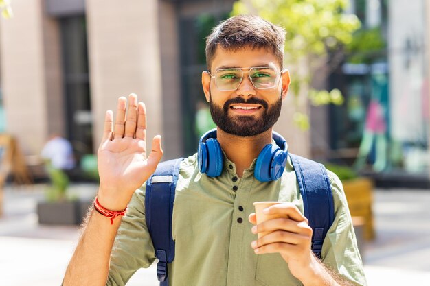 Estudante olhando feliz e mostrando gesto amigável ao ar livre