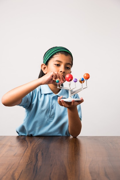 Estudante ou menina indiana estudando planetas ou ciências planetárias com o modelo 3D do nosso sistema solar