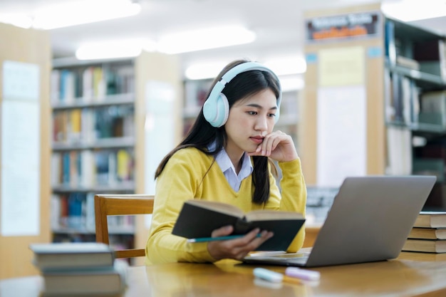 Estudante sentado e estudando com laptop na biblioteca