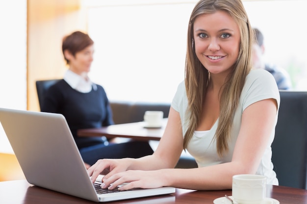 Estudante sentado no café com laptop