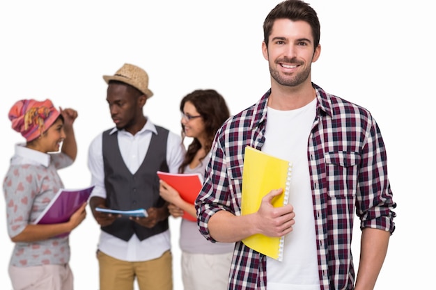 Estudante sorridente de pé com amigos atrás dele