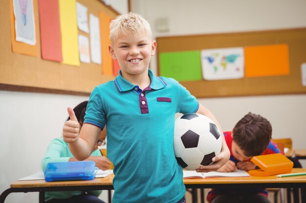 Estudante sorridente segurando um futebol