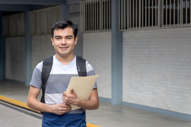 Foto estudante sorridente segurando um jornal na escola