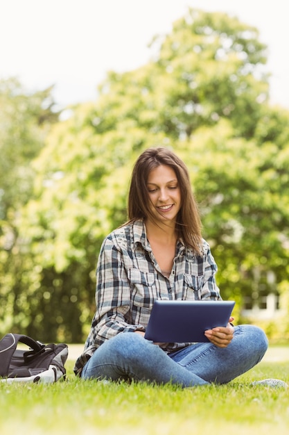 Estudante sorridente sentado e usando o tablet pc