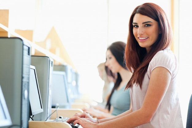 Estudante sorridente usando um computador