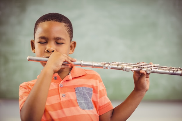 Estudante tocando flauta na sala de aula