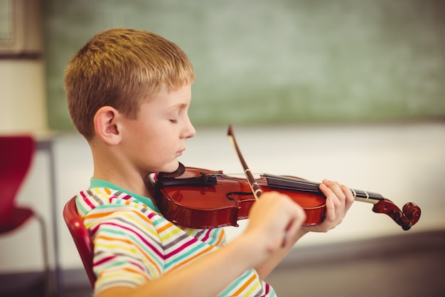 Estudante tocando violino na sala de aula