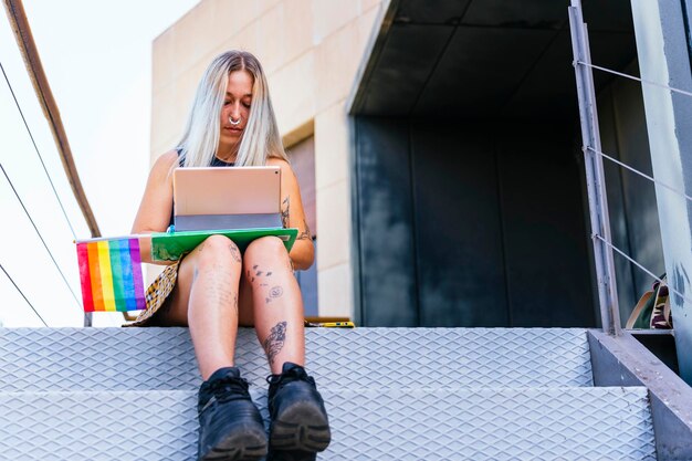 Estudante universitária moderna LGBT com bandeira do orgulho entre as pernas