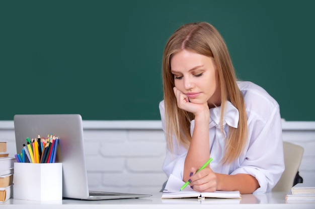 Estudante universitária trabalhando em um laptop na sala de aula se preparando para um exame Conceito de educação estudantil Aluna pensando em cursos na universidade