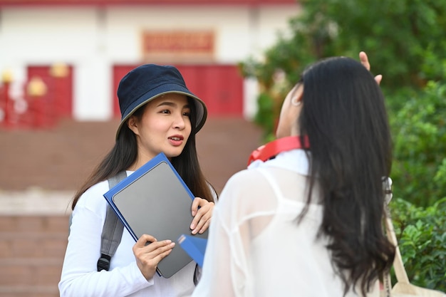Estudante universitário em pé no campus da faculdade e conversando com sua amiga sobre os resultados do exame