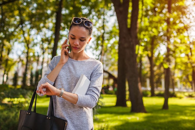 Estudante universitário falando no celular no parque